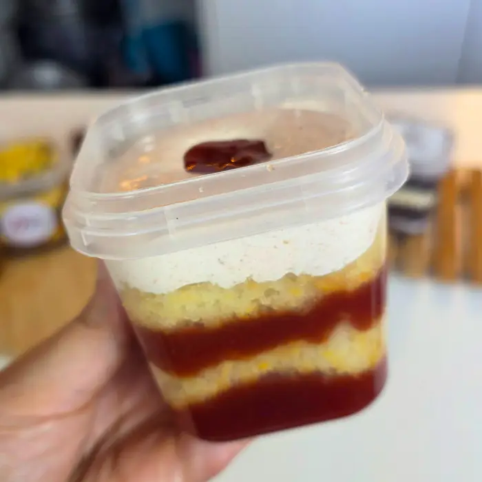 Detalhe de um bolo no pote da Dani, com massa clara e recheio de frutas